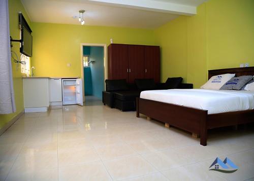 1 dormitorio con cama y sofá en DanRitzcer Suites, en Accra