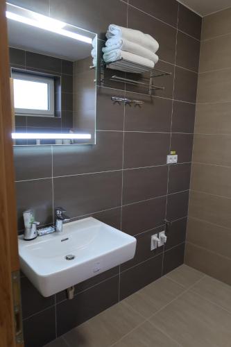 ein Badezimmer mit einem weißen Waschbecken und einem Spiegel in der Unterkunft Apartmán Matyáš in Drnholec