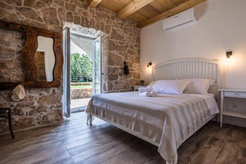 a bedroom with a bed and a large window at Stone Villa Katarina with pool in Klimno