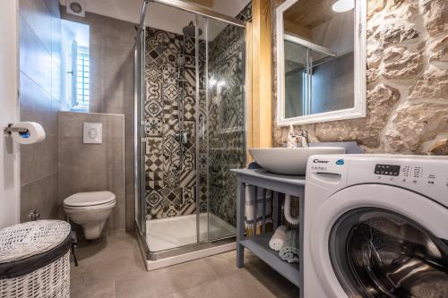 a bathroom with a washing machine and a sink at Stone Villa Katarina with pool in Klimno