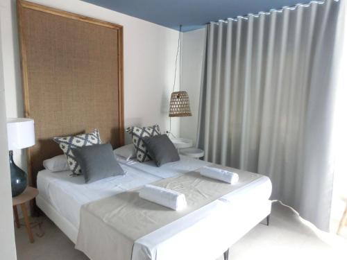 a white bedroom with two beds and a window at YOU & CO. Saler Beach Boutique in Valencia