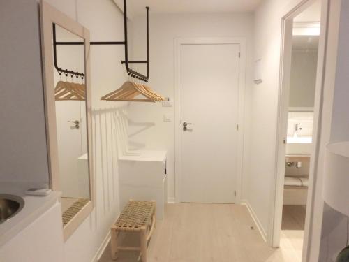 a white hallway with a door and a stool at YOU & CO. Saler Beach Boutique in Valencia