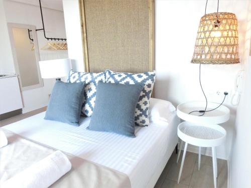 a small room with a white couch and blue pillows at YOU & CO. Saler Beach Boutique in Valencia