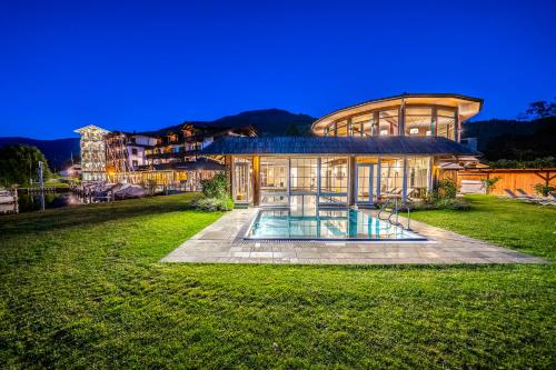 a large house with a pool in front of it at Hotel Seefischer - Finest Hideaway in Döbriach