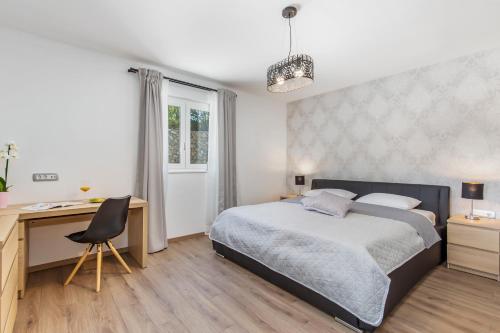 a bedroom with a bed and a desk and a desk at Apartment Niki in Opatija