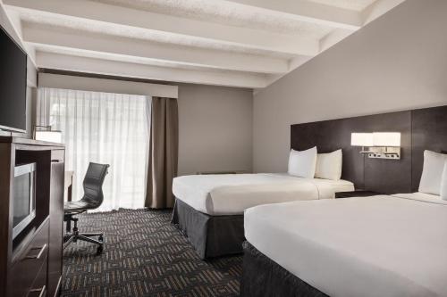 a hotel room with two beds and a television at Country Inn & Suites by Radisson, Woodbury, MN in Woodbury