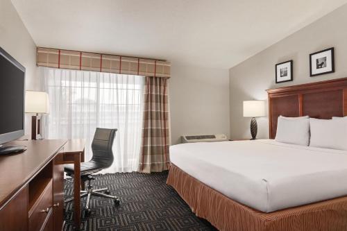 a hotel room with a bed and a desk at Country Inn & Suites by Radisson, Woodbury, MN in Woodbury