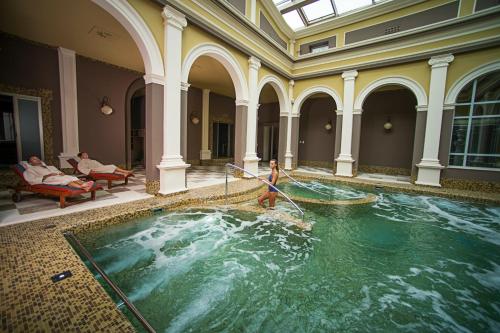 a person in a pool of water in a building at Bagni Di Pisa Palace & Thermal Spa - The Leading Hotels of the World in San Giuliano Terme