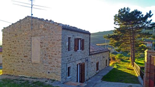 an old stone building with a tree next to it at Madonie Park Gates - Casa in C.Da Donalegge in Castellana Sicula