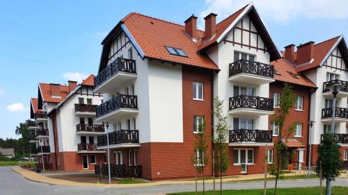 a large apartment building with a red roof at A może morze? in Sztutowo