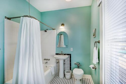 uma casa de banho com uma cortina de chuveiro branca e um lavatório. em Lakeside Inn on Lake Dora em Mount Dora
