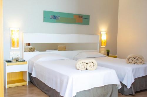 2 Betten in einem Hotelzimmer mit Handtüchern darauf in der Unterkunft Bristol Brasil 500 Curitiba Batel in Curitiba