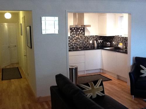 a kitchen and a living room with a couch at Flat 4 Summertown Court in Oxford