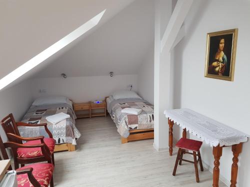 um quarto com 2 camas, uma mesa e cadeiras em Gościniec Słoneczny em Drzonków