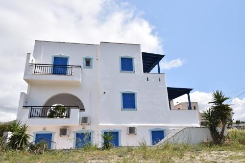 a white house with blue doors on the beach at Baetylus in Kastraki Naxou