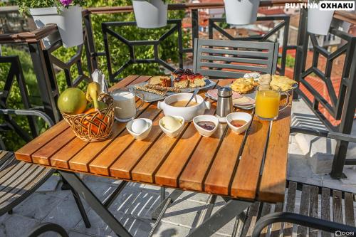 a wooden table with breakfast foods and drinks on it at Bujtina Oxhaku in Korçë