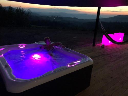 a hot tub with purple lights on a deck at Villa Panorama - Szklany Dom in Jaworzynka