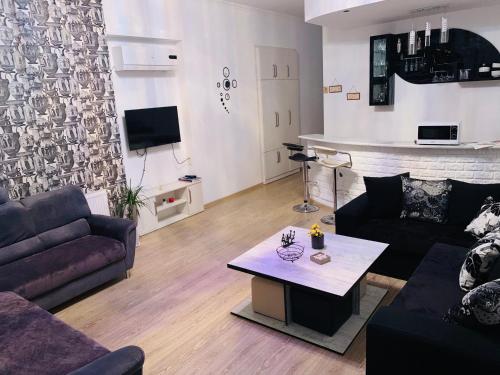 ein Wohnzimmer mit einem Sofa und einem Couchtisch in der Unterkunft AIA Apartment in Kutaissi