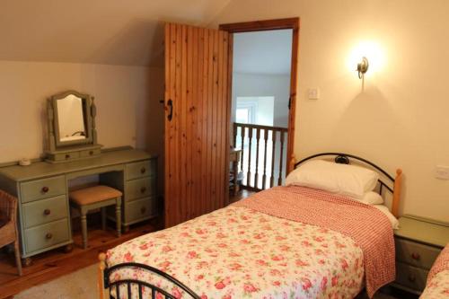 a bedroom with a bed and a dresser and a mirror at Hillcrest Cottage in Carrickfergus