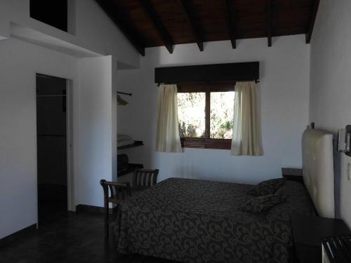 1 dormitorio con cama y ventana en Pineta 4 y 7 en Villa Gesell