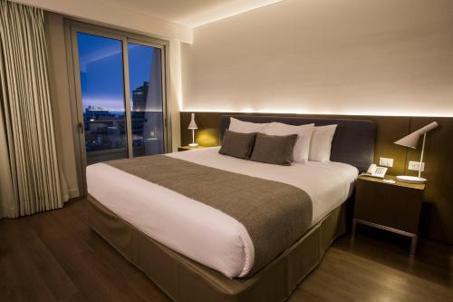 een slaapkamer met een groot bed en een groot raam bij Dazzler by Wyndham Lima San Isidro in Lima