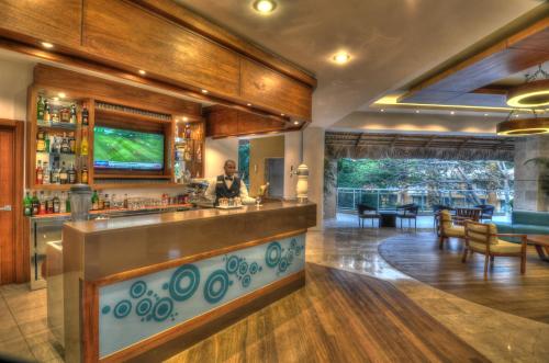 a bar in a restaurant with a person standing behind the counter at Viva Dominicus Palace by Wyndham, A Trademark All Inclusive in Bayahibe