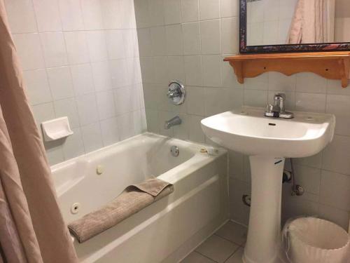 a bathroom with a sink and a bath tub and a sink at Rainbow Lake Castle Resort in Princeton