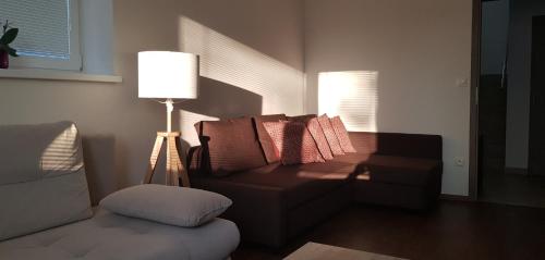 a living room with a couch and a lamp at VIP Apartmány Žabník in Prievidza