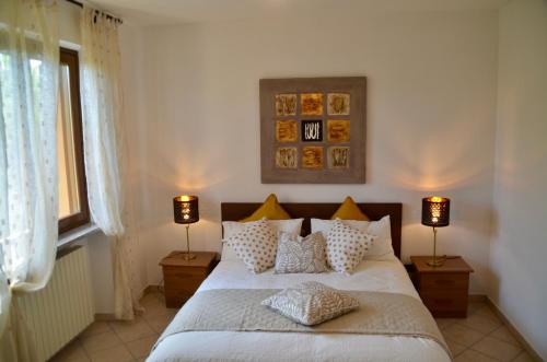 a bedroom with a bed with pillows and two lamps at Villa Patrizia in Moncalvo