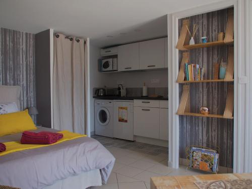 a bedroom with a bed and a kitchen at Une Heure Bleue in Manosque