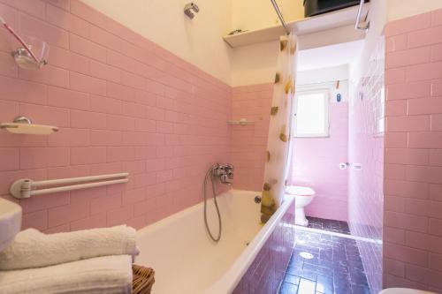een roze badkamer met een bad en een douche bij old corallo in Rome
