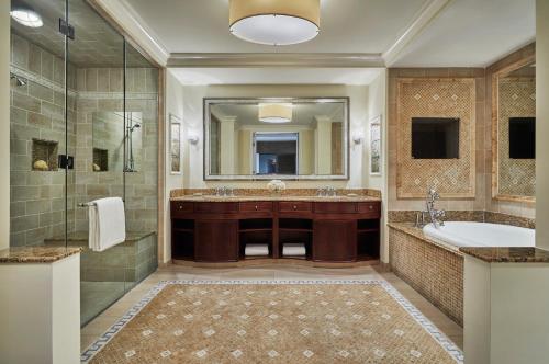 ein Bad mit einer Badewanne, einem Waschbecken und einer Dusche in der Unterkunft The Ocean Club, A Four Seasons Resort, Bahamas in Nassau