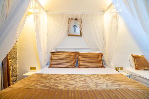 - une chambre avec un lit à baldaquin dans l'établissement Tas Otel 17, à Assos