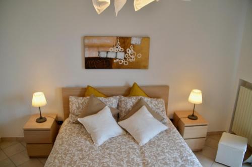 a bedroom with a bed with pillows and two lamps at Villa Patrizia in Moncalvo