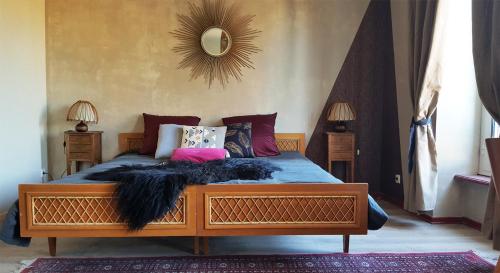 a bedroom with a wooden bed with a black blanket at les forges du lou in Jugon Les Lacs