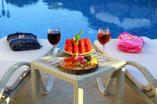 Salbakos Herakleia Hotel في ألاتشاتي: طاولة مع صحن من الفاكهة وكأسين من النبيذ
