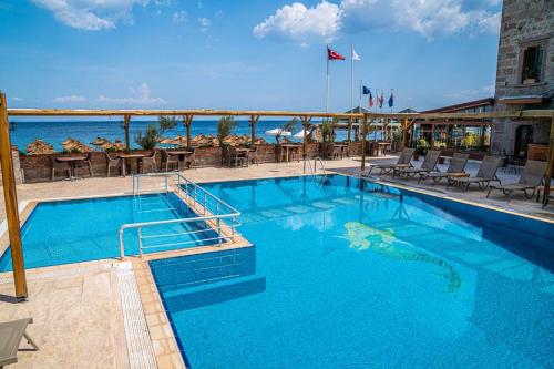 a large swimming pool with aigators reflection in the water at Assos Kervansaray Hotel - Special Category in Behramkale