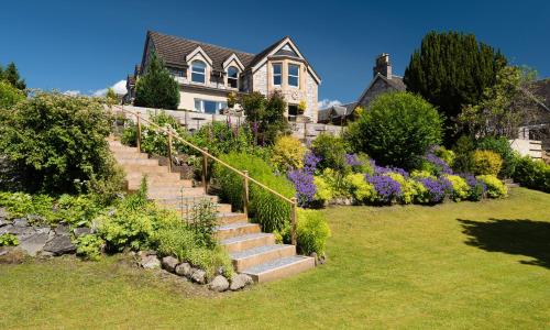 una casa con un jardín con escaleras y flores en Derrybeg Bed and Breakfast, en Pitlochry