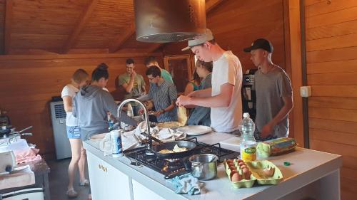 a group of people standing in a kitchen preparing food at Apartments Šeherzada in Pula