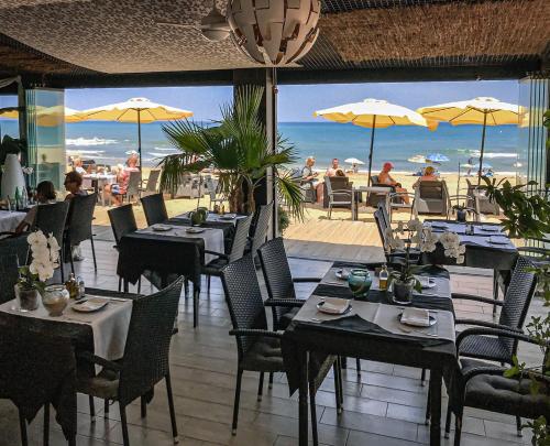 a restaurant with tables and chairs with a view of the beach at Lloyds Beach Club in Torrevieja