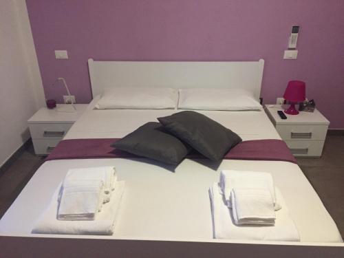 1 cama blanca grande con 2 almohadas en Pit Lane AFFITTACAMERE, en Offida
