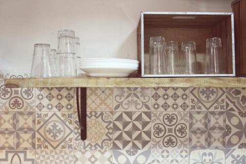 una encimera de cocina con vasos y platos. en Casa Rural Teresa, en El Molar