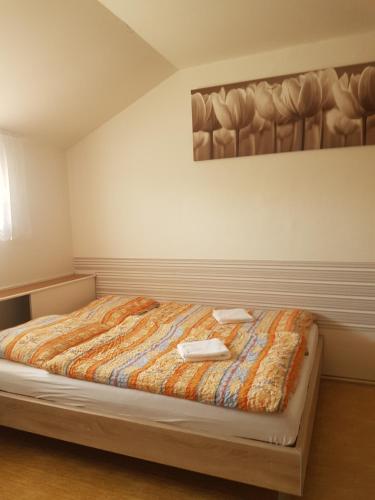 a bedroom with a bed with a painting on the wall at Penzion Pasohlávky in Pasohlávky