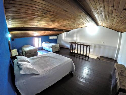 a bedroom with a large bed and a wooden ceiling at Departamento Centro de Búzios in Búzios