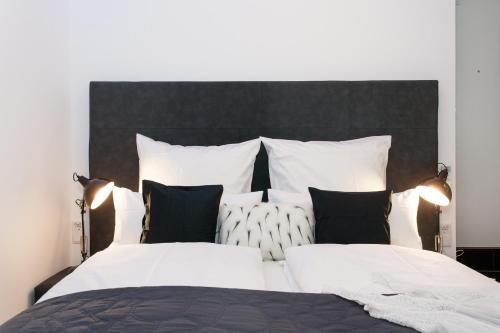 um quarto com uma cama grande e almofadas pretas e brancas em Main Flat Frankfurt Offenbach em Offenbach