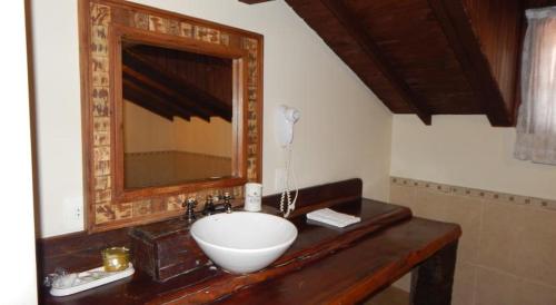 a bathroom with a sink and a mirror at Pousada Quinta dos Pássaros Itaipava in Itaipava