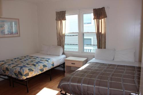 a bedroom with two beds and a window at Blue Haven Apartments in Ocean City