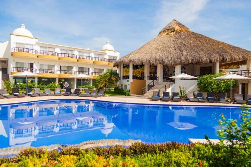 a hotel room with a pool and a beach at Quinta Bella Huatulco in Santa Cruz Huatulco