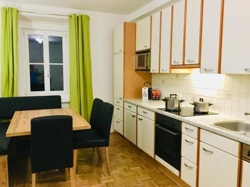 a small kitchen with a wooden table and a kitchen counters at Alpenaquarium Grüblsee - FEWO Elfi in Vordernberg