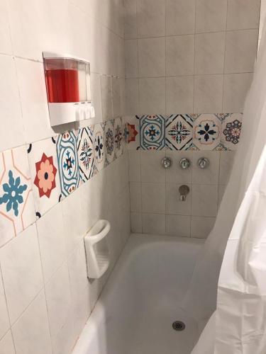 a bathroom with a tub and a toilet paper dispenser at apart Italia in Río Cuarto